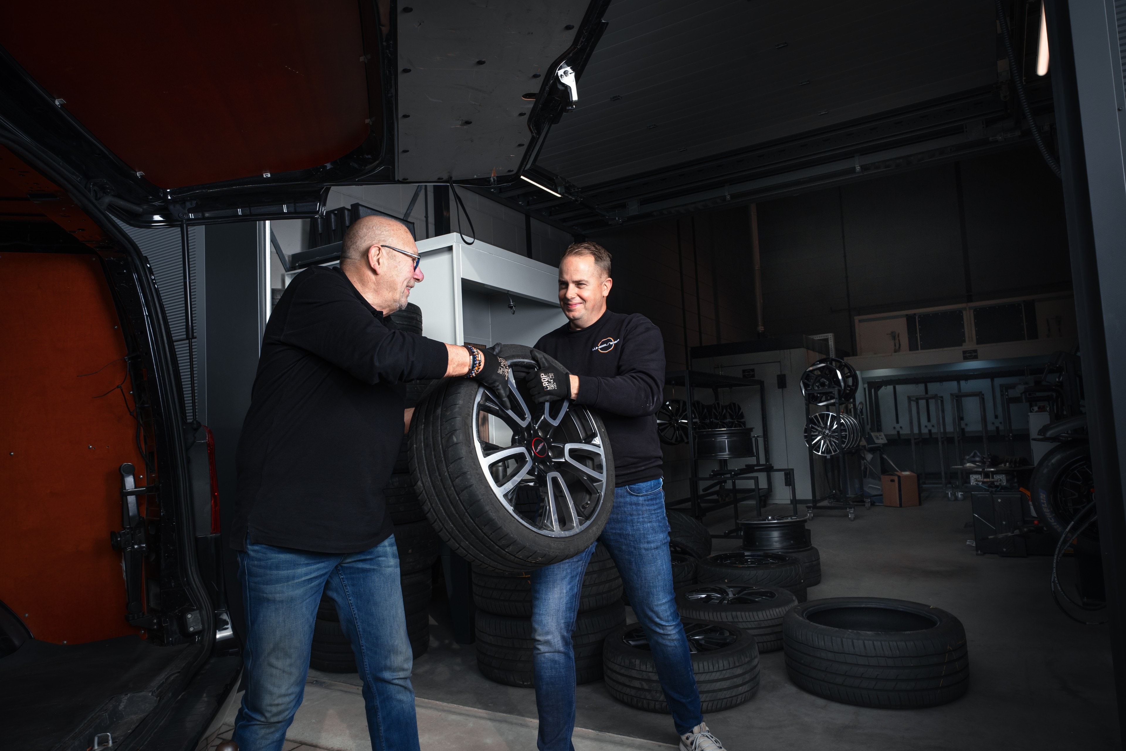 Koen en Joop tillen een wiel uit de bus
